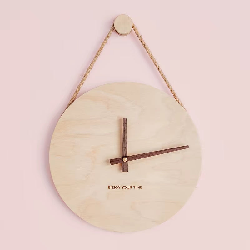 Horloge suspendue bois clair et corde sur fond rose pastel