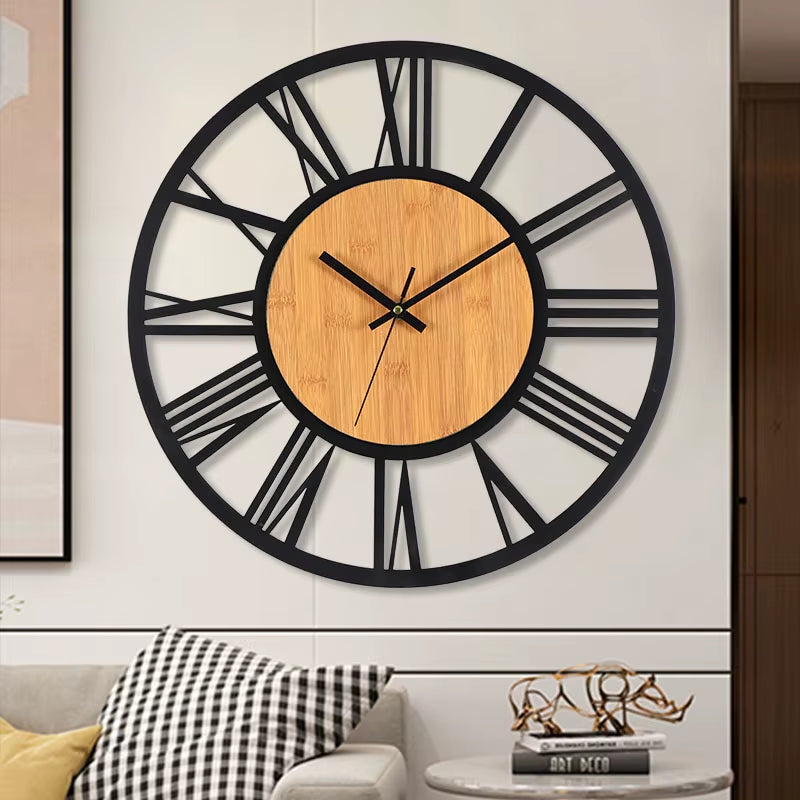 Horloge murale industrielle avec centre en bois naturel et chiffres romains en métal noir fixée sur un mur blanc décoratif